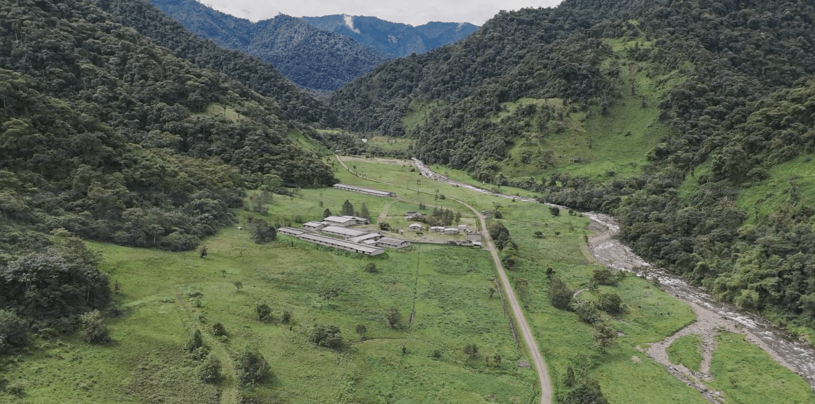 Vista aérea de las instalaciones de Agroindustrias González en un valle amazónico, rodeadas de bosque y montañas